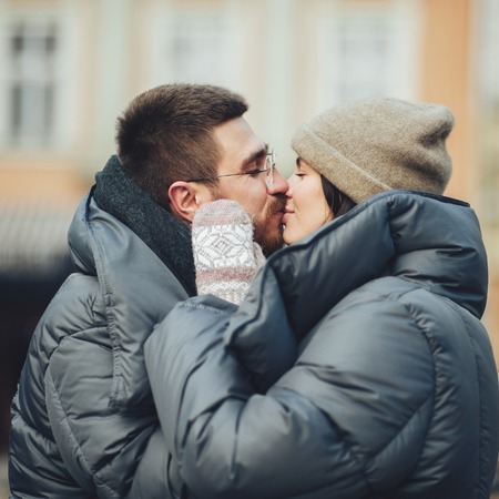 Classy groom and his gorgeous bride pose outside in winter coatsの写真素材