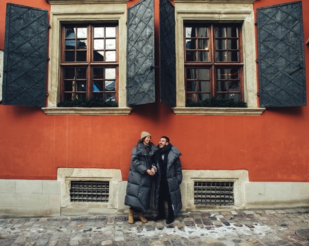 Classy groom and his gorgeous bride pose outside in winter coatsの写真素材
