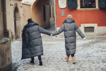 Classy groom and his gorgeous bride pose outside in winter coatsの写真素材