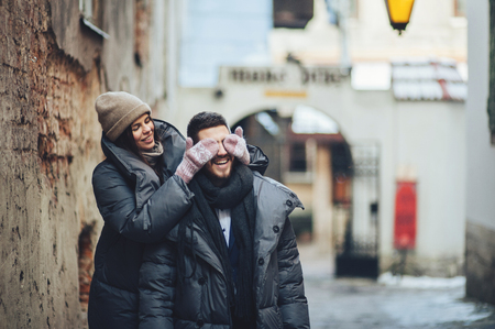 Classy groom and his gorgeous bride pose outside in winter coatsの写真素材