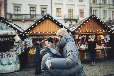 Happy couples on the city square decorated for a Christmas markeの写真素材