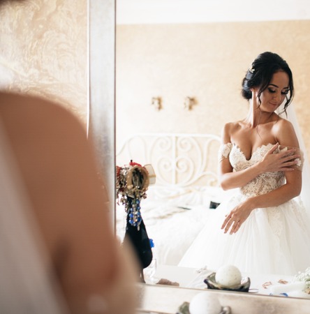 Beautiful bride and bridesmaids posing in room before weddingの写真素材