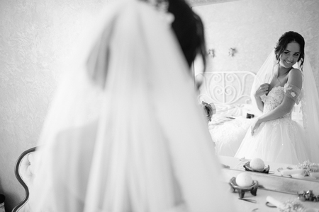 Beautiful bride and bridesmaids posing in room before weddingの写真素材