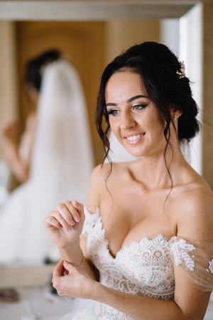 Beautiful sexy bride in white dress posing under curtainの写真素材