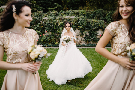 Bride with bridesmaids on the park on the wedding dayの写真素材