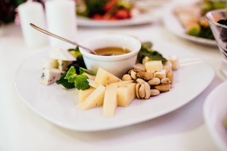 Photo of cheese platter and salad on the tableの写真素材