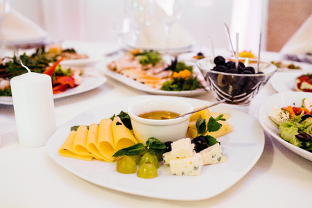 Photo of cheese platter and salad on the tableの写真素材