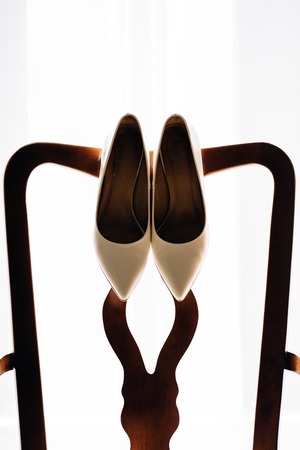 beautiful stylish luxury wedding shoes on the background of a windowの写真素材