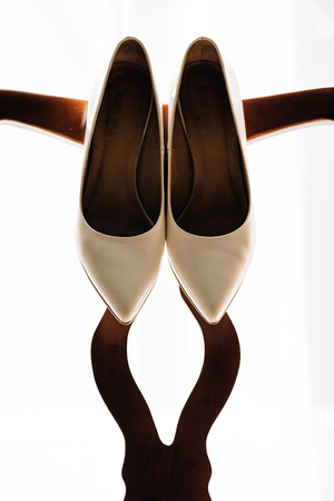 beautiful stylish luxury wedding shoes on the background of a windowの写真素材