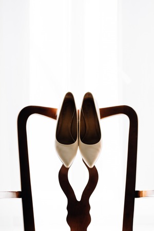 beautiful stylish luxury wedding shoes on the background of a windowの写真素材