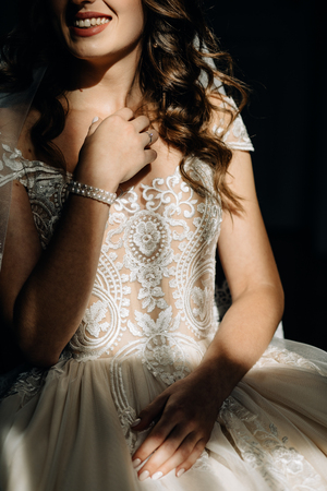 Sexy bride in white silk robe stands with closed eyes before the wallの写真素材