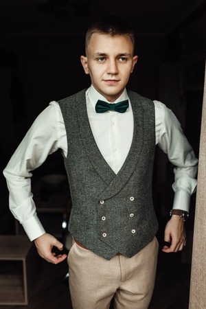 Handsome groom waiting for bride in luxury hotel roomの写真素材