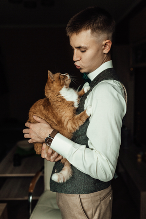 Cat hold by a groom while  preparing for wedding ceremonyの写真素材