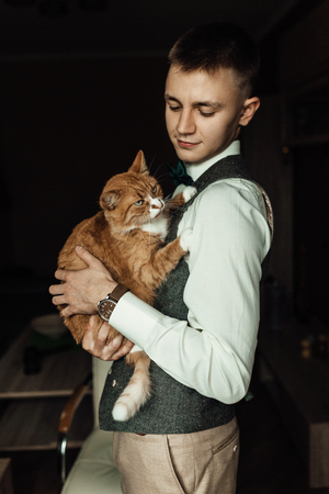 Cat hold by a groom while  preparing for wedding ceremonyの写真素材