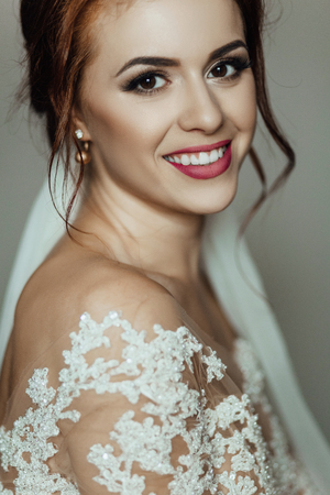 Stunning bride with shiny skin stands in the roomの写真素材