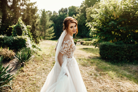 The beautiful bride in a white poses in the parkの写真素材