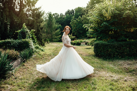The beautiful bride in a white poses in the parkの写真素材