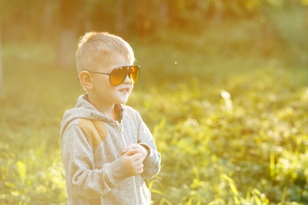 Boy in sunglasses in summer, toned photoの写真素材