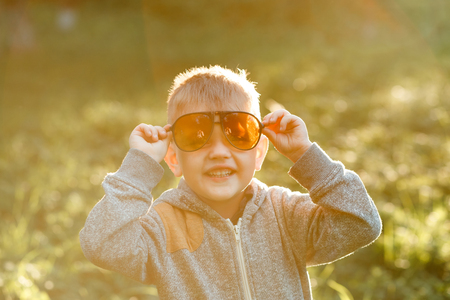 Boy in sunglasses in summer, toned photoの写真素材