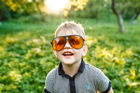 Boy in sunglasses in summer, toned photoの写真素材