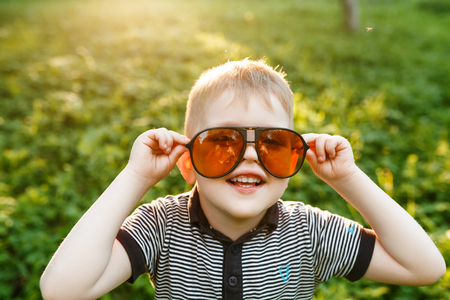 Boy in sunglasses in summer, toned photoの写真素材