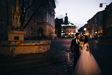 Bride and groom walking through the old townの写真素材