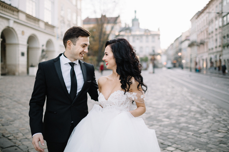 Bride and groom walking through the old townの写真素材