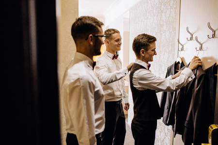 stylish groom laughing and having fun with groomsmen while gettiの写真素材