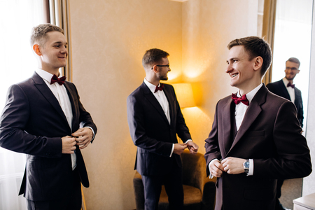 Three handsome male friends meet and speeking each other. Groomsの写真素材