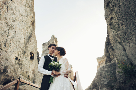 Amazing wedding couple is hugging each other in mountainsの写真素材
