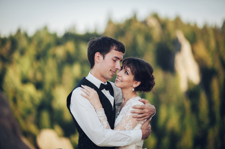 Luxury wedding couple is hugging each other in mountainsの写真素材