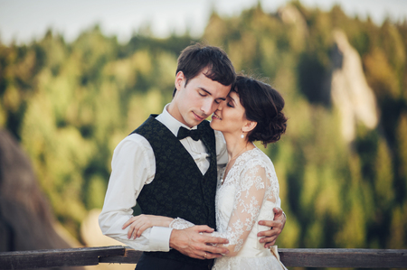 Amazing wedding couple is hugging each other in mountainsの写真素材