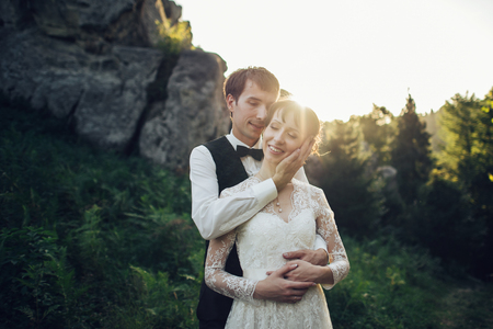 Amazing wedding couple is hugging each other in mountainsの写真素材