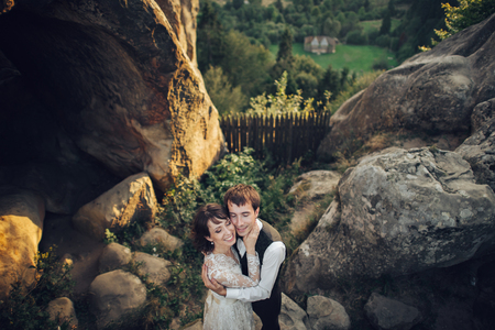 Amazing wedding couple is hugging each other in mountainsの写真素材