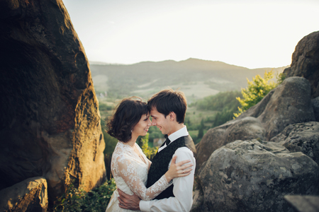 Amazing wedding couple is hugging each other in mountainsの写真素材