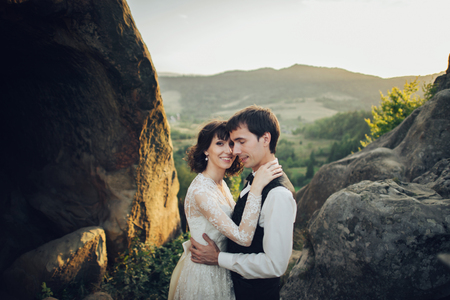 Luxury wedding couple is hugging each other in mountainsの写真素材