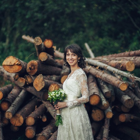 Beautiful bride in elegant white dress holding bouquet posing inの写真素材