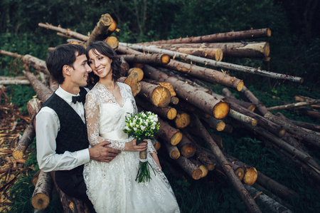 Gorgeous bride and stylish groom walking at sunny landscape, wedの写真素材