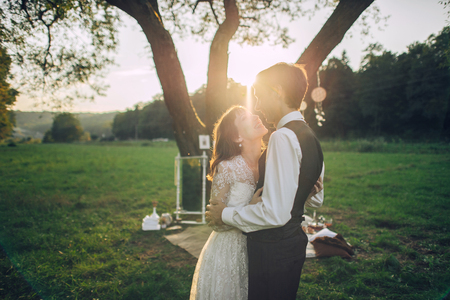 Attractive Couple Enjoying Romantic Sunset Picnic in the Countryの写真素材