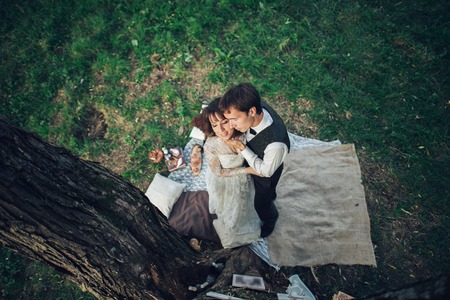 Attractive Couple Enjoying Romantic Sunset Picnic in the Countryの写真素材
