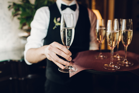 waiter brings glasses of champagneの写真素材