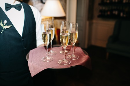 waiter brings glasses of champagneの写真素材