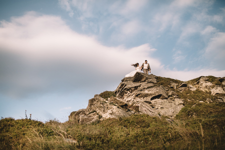 Romantic couple standing together holding hands in the mountainsの写真素材