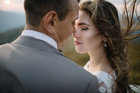 Romantic couple standing together holding hands in the mountainsの写真素材