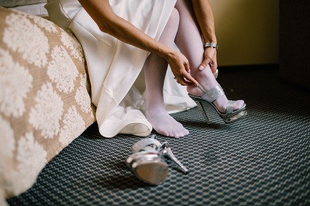 Bride in the dress in the white bridal shoesの写真素材
