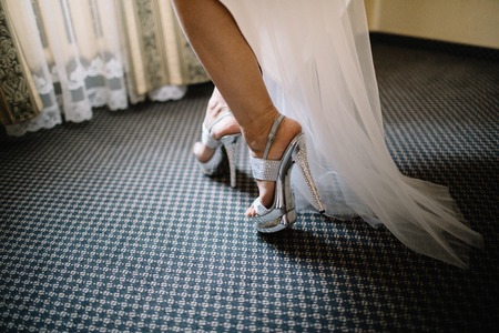 Bride in the dress in the white bridal shoesの写真素材