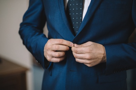 Dressing groom and preparing for ceremonyの写真素材