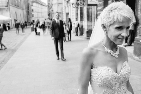 Happy smiling newlyweds walking outdoors, kissing and embracingの写真素材