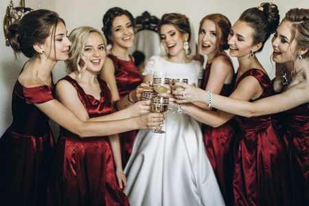 Bride and bridesmaid toasting for wedding ceremony in hotel roomの写真素材