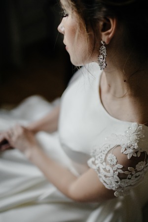Closeup shot of an elegant, brunette bride in vintage white dres